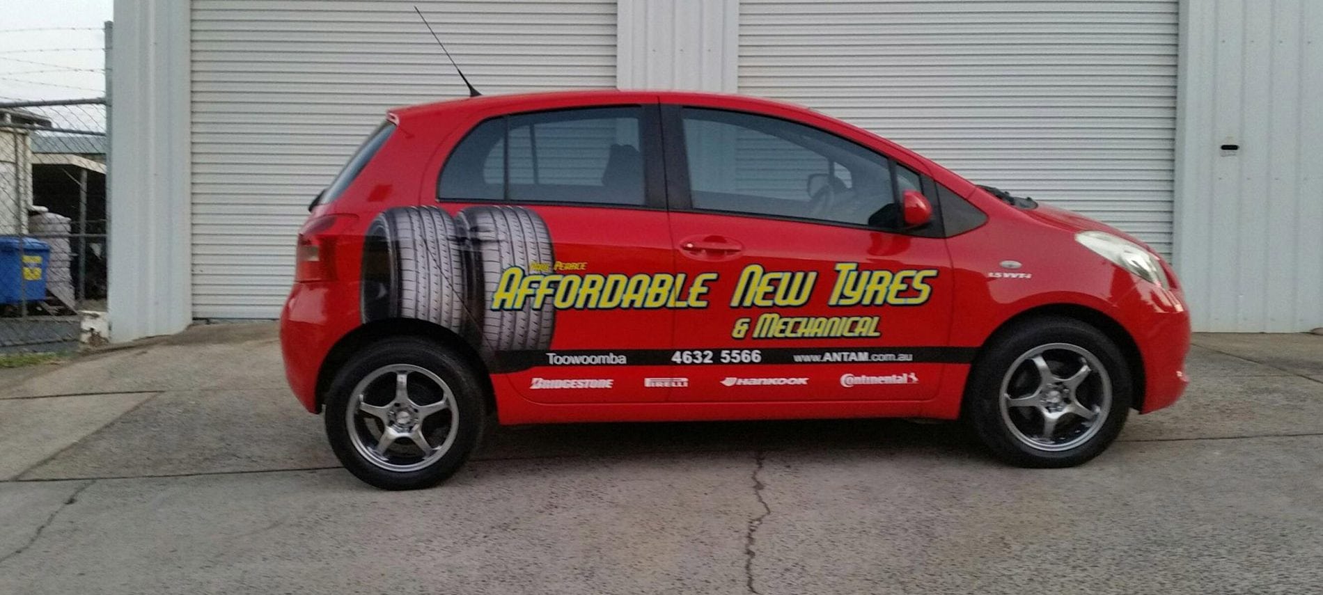 Business car parked in front of a mechanical shop