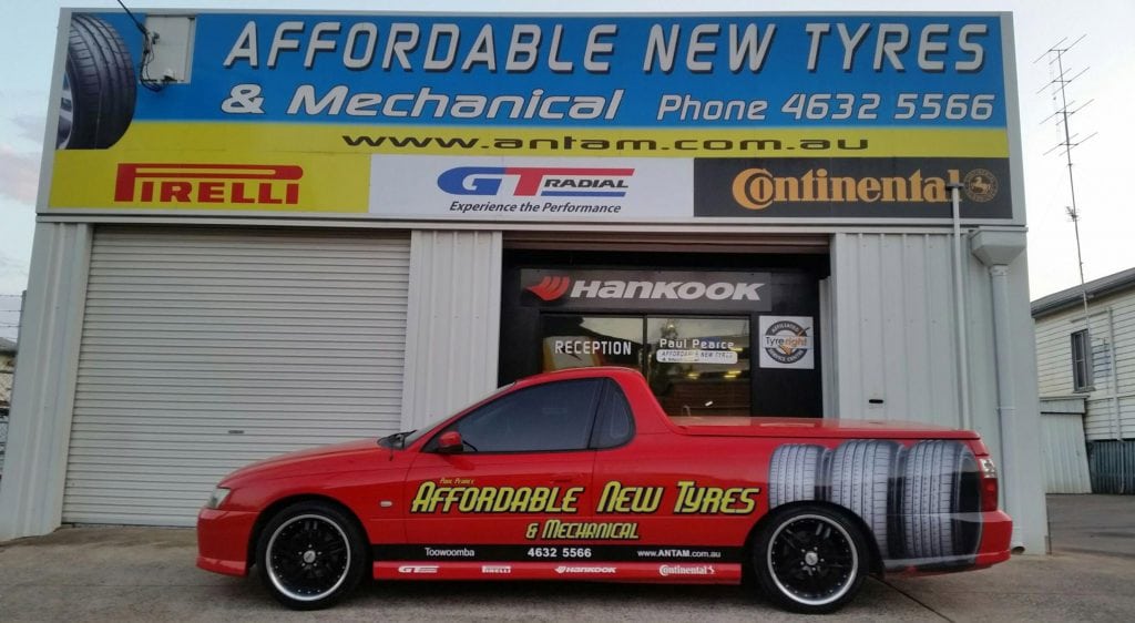 Business car parked in front of a mechanical shop