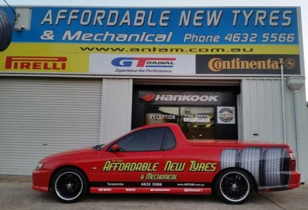 Business car parked in front of a mechanical shop