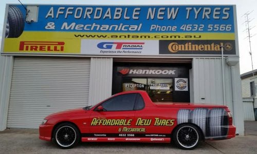 Business car parked in front of a mechanical shop