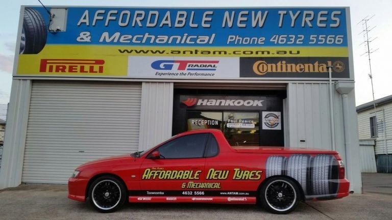 Business car parked in front of a mechanical shop