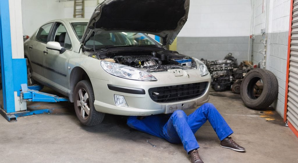 Male mechanic working on a car service