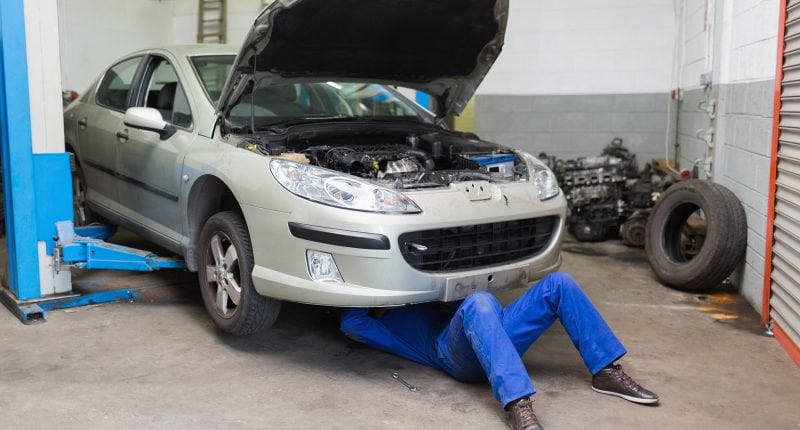 Male mechanic working on a car service